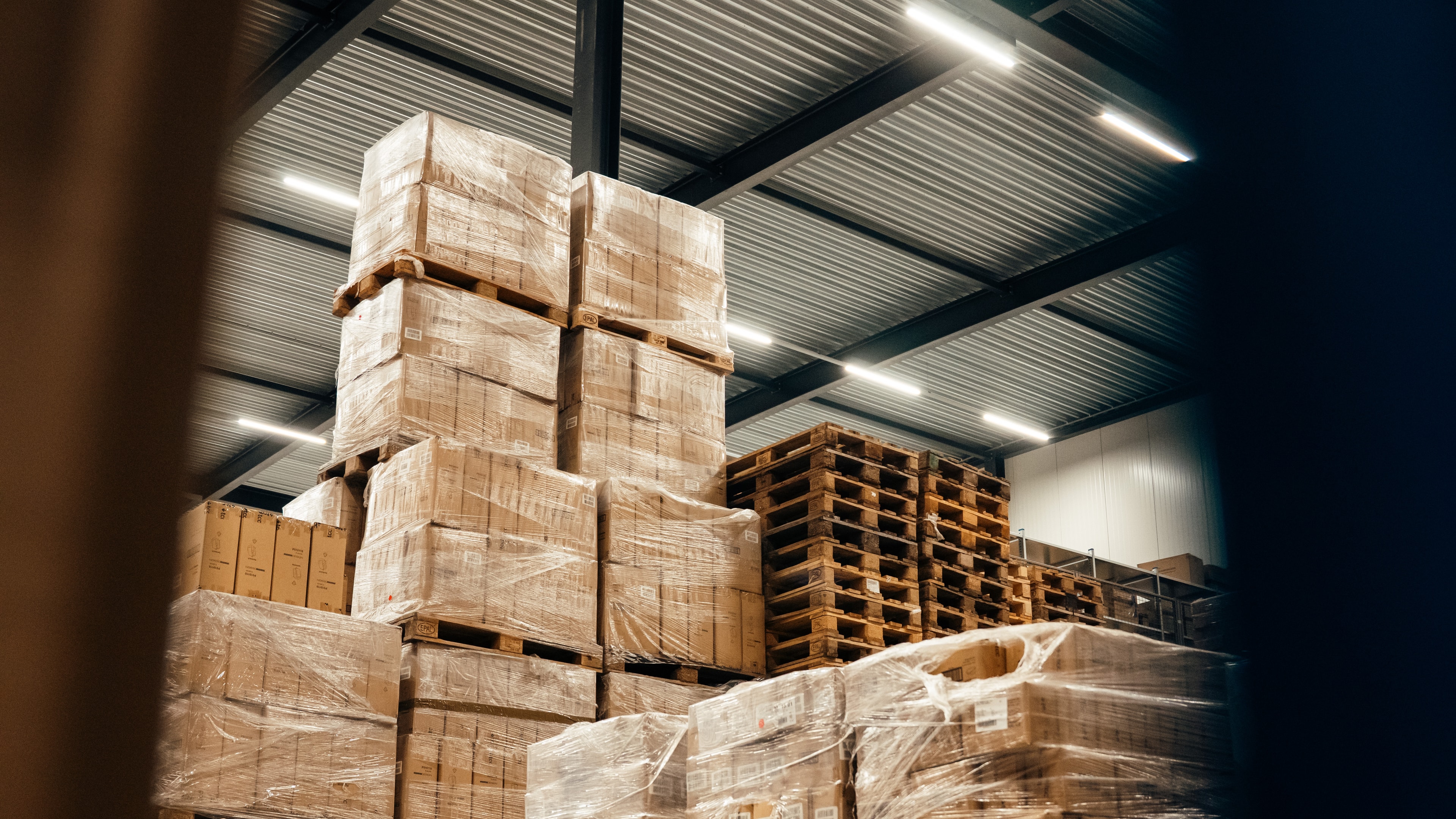 Gestapelde en ingepakte pallets met dozen in een distributiecentrum
