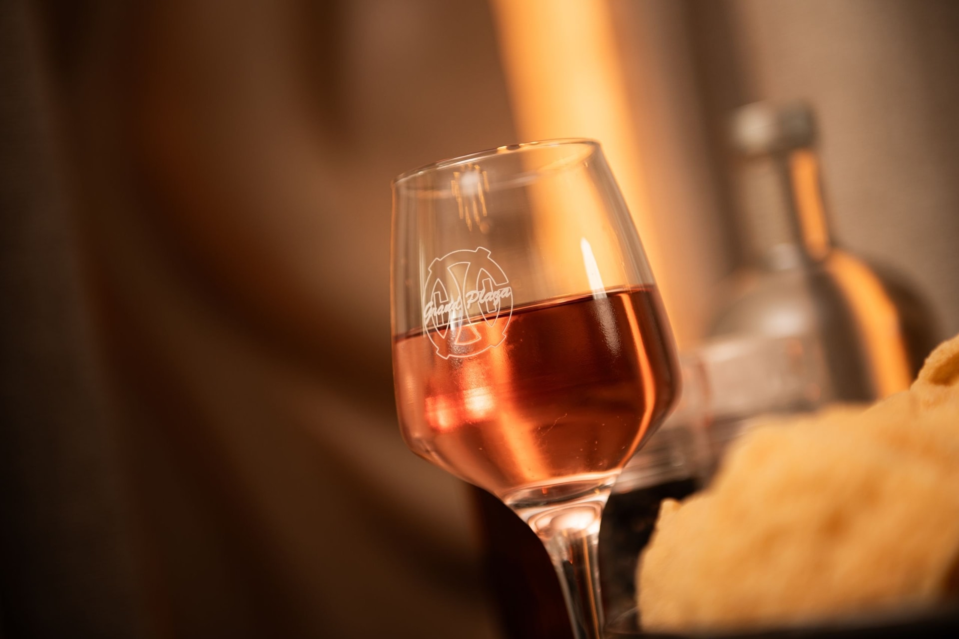 Wijnglas met het logo van Grand Plaza, close-up aan tafel