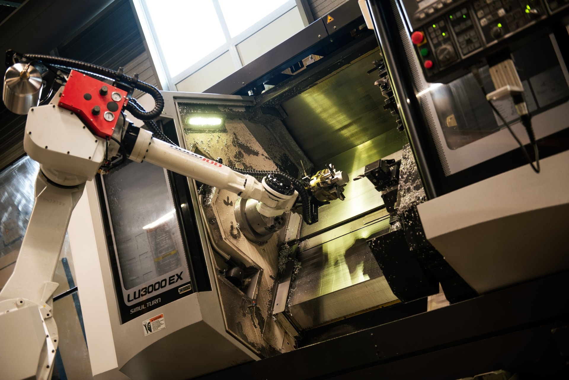 Close-up van de robotarm van een CNC-draaibank tijdens het bewerken van een onderdeel
